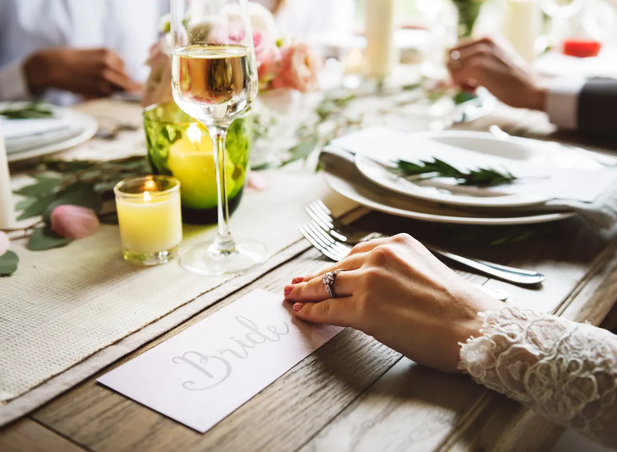 A rustic place setting with eucalyptus sprigs on a linen runner