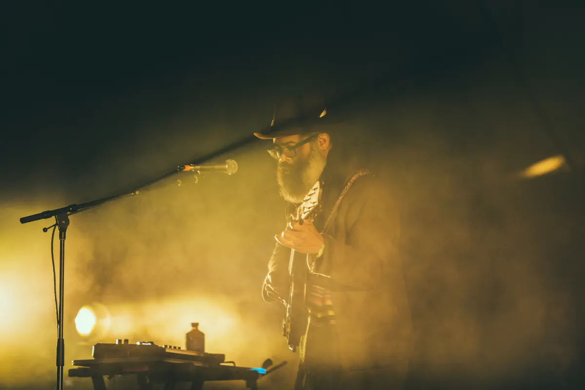 A guitarist on stage in amber haze